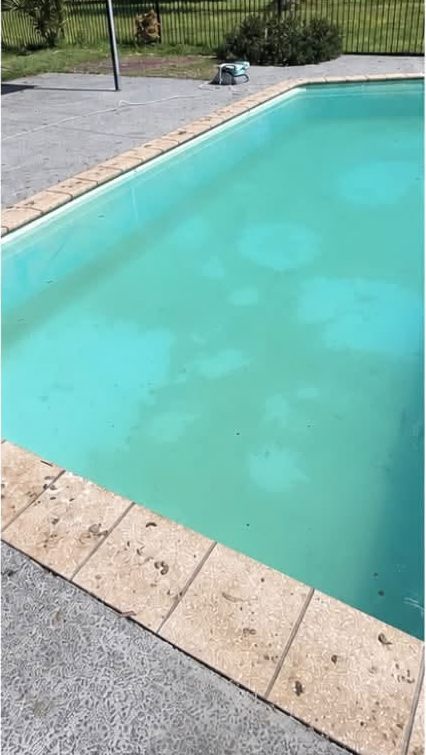 The same pool part-way through treatment, water cloudy but no longer green